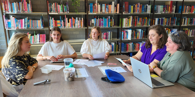 De vijf studenten overleggen over Taaldorp
